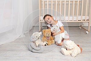 Little girl 5-6 years old playing in the children`s room with Teddy bears