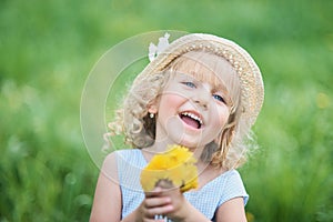 Little girl 5 years old sniffing a dandelion