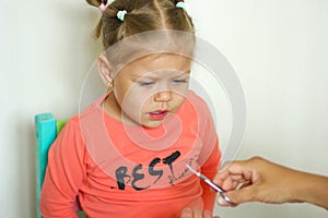 Little girl afraiding of trimming fingernails by manicure scissors