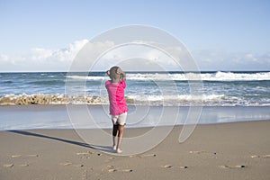 Little girl alone on beach.