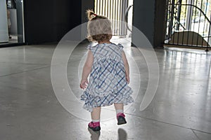 A little girl alone on the landing. Concept: orphanages, orphans left by parents, unattended in the store, lost people. photo