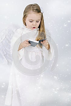 A little girl angel with a book