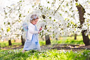 Little girl in apple tree garden