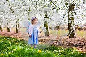 Little girl in apple tree garden