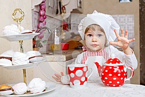 Little girl in apron in the kitchen.