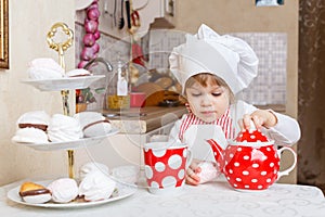 Little girl in apron in the kitchen.