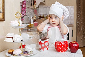 Little girl in apron in the kitchen.