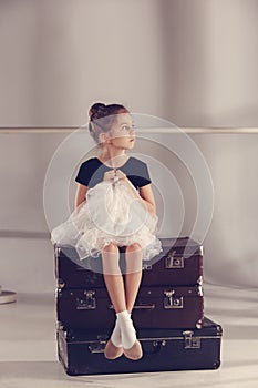 The little girl as balerina dancer sitting at studio