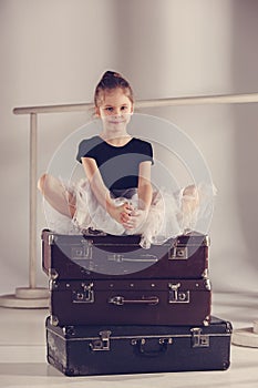 The little girl as balerina dancer sitting at studio