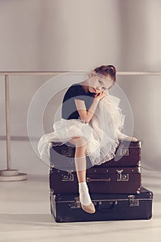 The little girl as balerina dancer sitting at studio