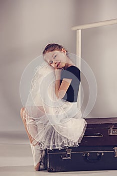 The little girl as balerina dancer sitting at studio