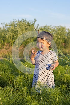 Little girl as indian with maracas and feather