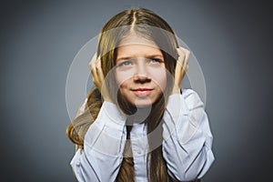 Little girl with astonished expression while standing against grey background