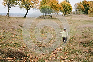 Little girl in the autumn park. run pathway