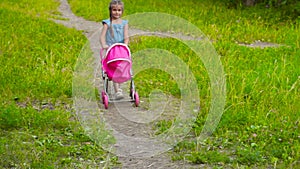 Little girl with baby doll in park with stroller