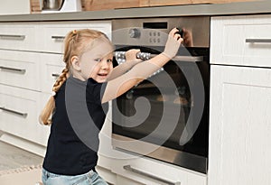 Little girl baking cookies in oven