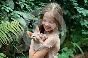 Little girl with bald sphinx cat