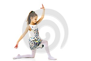 Little girl ballerina in the image posing on the floor.