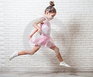 The little girl ballerina in a tricot doing a jump