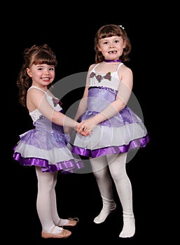 Little girl ballet dancers holding hands. Isolated