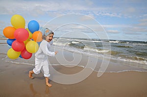 Little girl with balloons on the beach