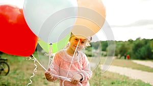 Little girl with balloons in the park