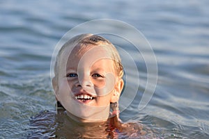 Little girl bathes in the sea, portrait, wet hair