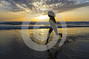 Little girl bathing on the beach at dusk