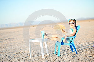 Little Girl In Bathing Suit With Fan In Hot Desert