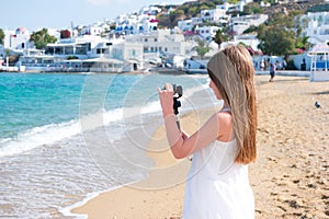 Little girl on the beach with GoPro camera making photo