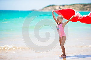 Little girl with beach towel during tropical