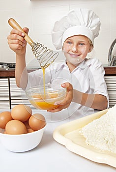 Little girl beating eggs