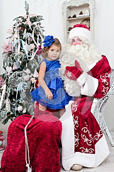 Little girl in a beautiful blue dress sits on a lap at Saint Nicolas