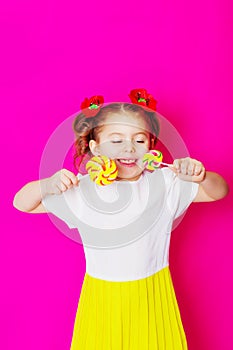 Little girl in a beautiful dress with a big candy lollipop