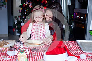 Little girl with beautiful mother baking Christmas