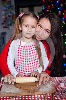 Little girl with beautiful mother baking Christmas