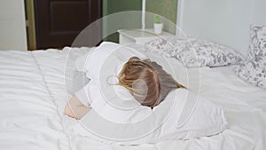 a little girl on a bed in the bedroom and cries with face buried in the pillow
