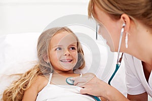 Little girl in bed having a health check