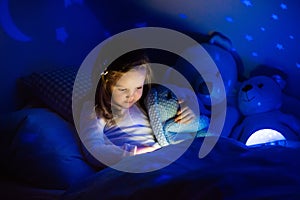 Little girl in bed with night lamp