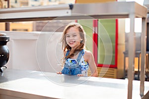 Little girl behind an empty counter, serving table