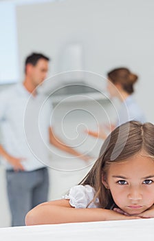 Little girl being sad while parents are quarreling photo