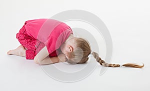 Little girl bending and closing her eyes in the squatting positi