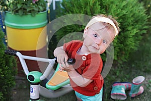 Little girl on bicycle. Kid biking outdoors in village.