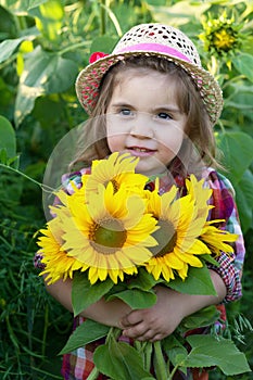 Little girl with a big bouquet of sunflowers