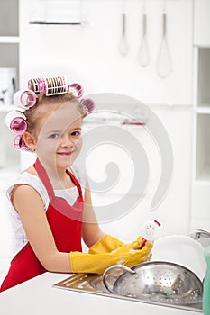 Little girl with big curls doing the dishes