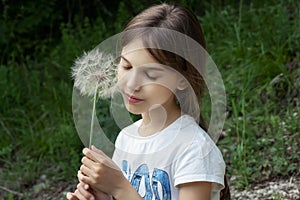 Little girl with a big dandelion in her hand