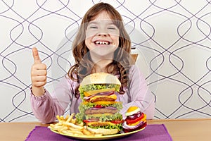 Little girl with big hamburger and thumb up