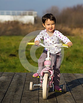 Little girl on a bike near the house