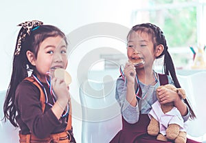 Little girl bitting gold medal for student award