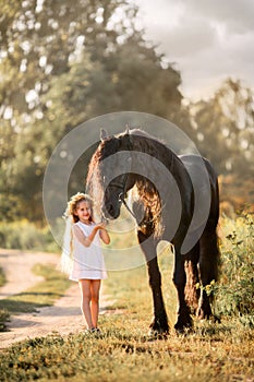 Little girl with black friesian stallion